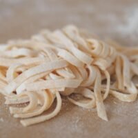 طبق نودلز على طاولة خشبية، يظهر شكل النودلز وطبيعتها البسيطة