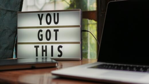Lit sign with 'You Got This' alongside laptop on office desk.